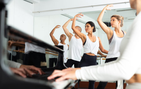 Group of men and women practicing at ballet barre