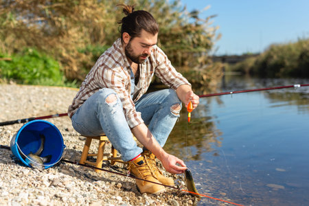 Positive fisherman holding catch freshwater fish in hands