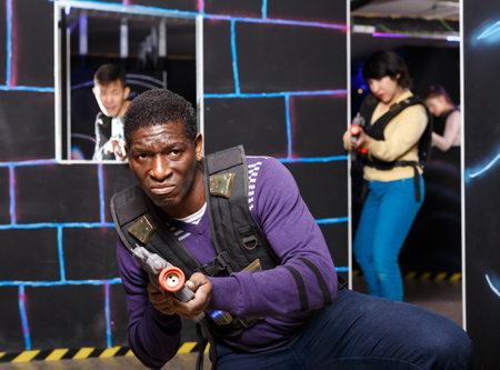 African man playing laser tag with friendsの写真素材