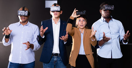 Group of friends are wearing virtual reality goggles in quest roomの写真素材