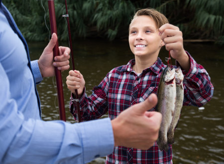 Positive young boy holding on hook fishの写真素材