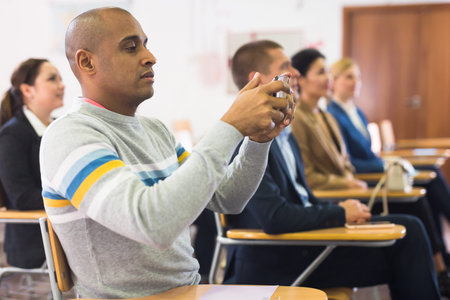 Man recording lecture on smartphone at conferenceの写真素材