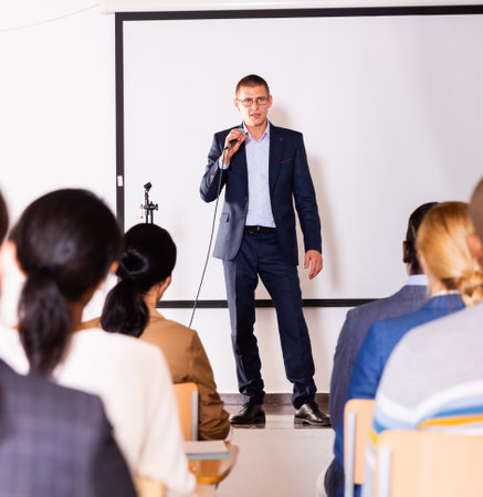 Confident man with microphone speaking at corporate business eventの写真素材