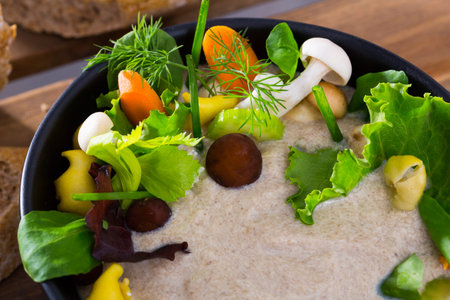 Cream soup with shitake mushroom served with vegetables and greensの写真素材