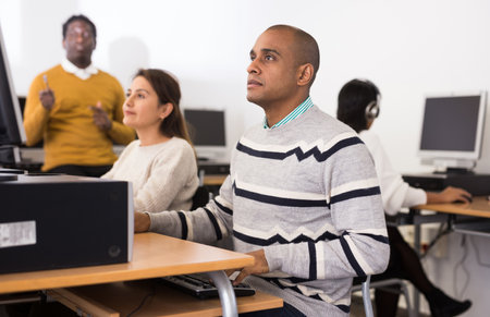 Young adult man studying in computer classの写真素材