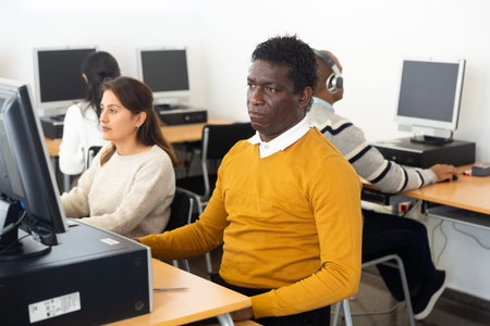 Young adult man studying in computer class