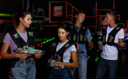 Two pretty girls talking during laser tag gameの写真素材