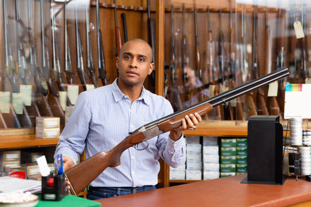 Seller demonstrates a combat winchester in gun storeの写真素材