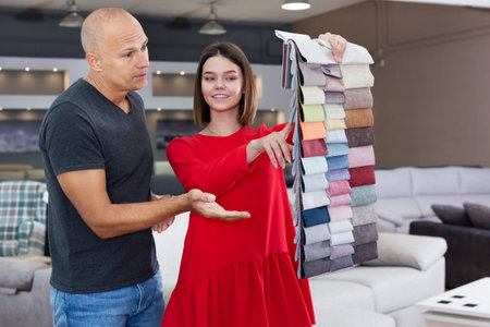 Consultant helping man choosing upholstery fabricの写真素材