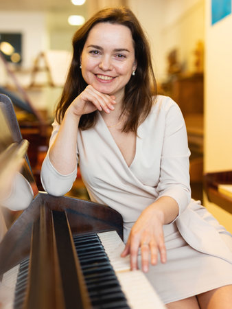 Young woman buys pianoforte in a music storeの写真素材
