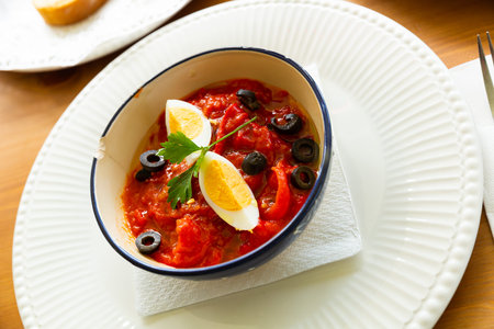 Salad of baked red peppers with boiled egg and olives