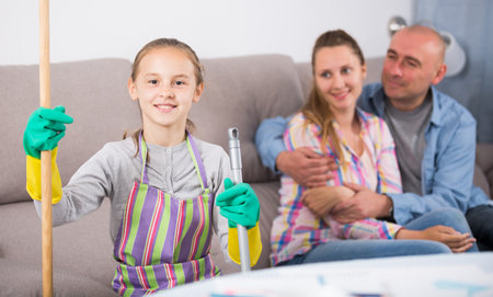 Smiling girl sitting after cleaning homeの写真素材