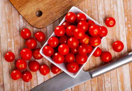 Fresh organic cherry tomatoes on wooden tableの写真素材