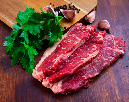 Raw marbled beef entrecotes with parsley and spices