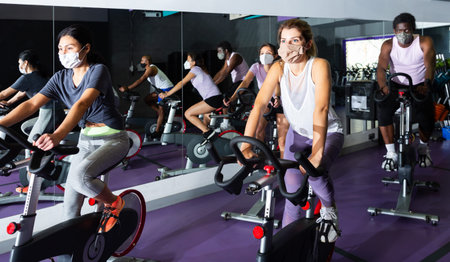 People training on cycling machines in gym