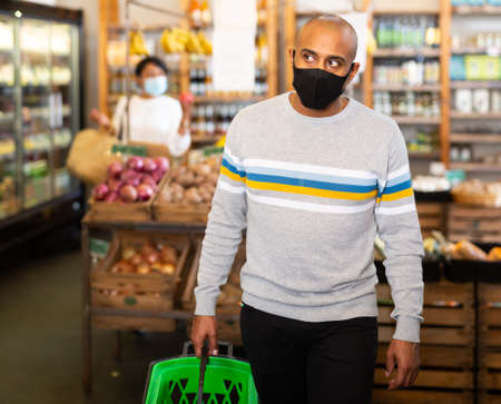 Hispanic man in protective mask visiting grocery storeの写真素材
