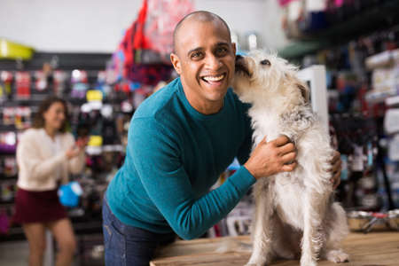 Portrait of man with beloved dog in pet shopの写真素材