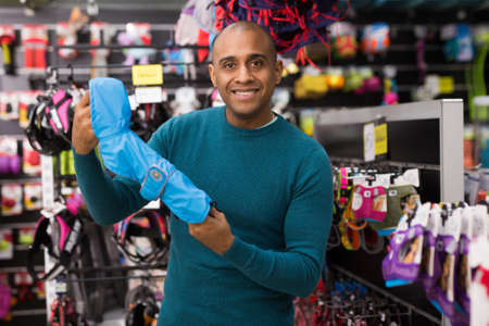 Man choosing clothes for dog in shopの写真素材