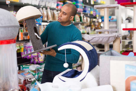 Man choosing cat furniture supplies in shopの写真素材