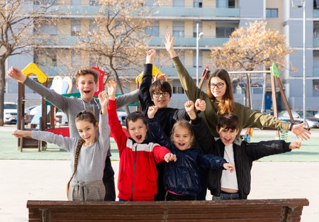 Portrait of happy kids standing together on playground in spring day
