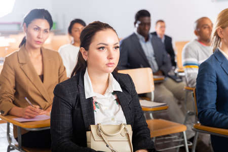 Focused woman listening to lecture at conferenceの写真素材