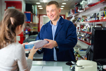 Positive administrator of the printing house gives finished product to the buyerの写真素材