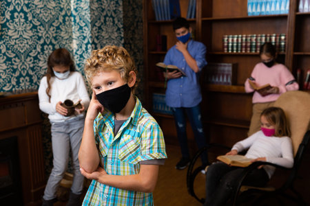Tween boy in protective mask solving puzzles in escape roomの写真素材