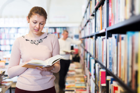 Female reading books in bookshop