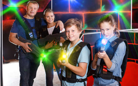 Glad boy and girl posing with laser gunsの写真素材
