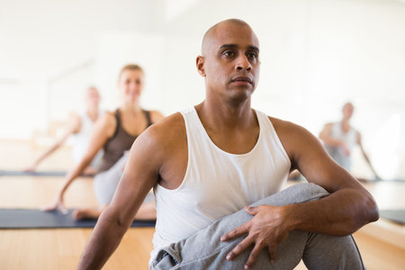 Man making yoga exercises at group class