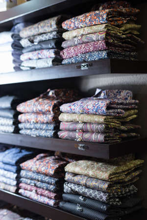 Men shirts displayed on shelves in shopの写真素材
