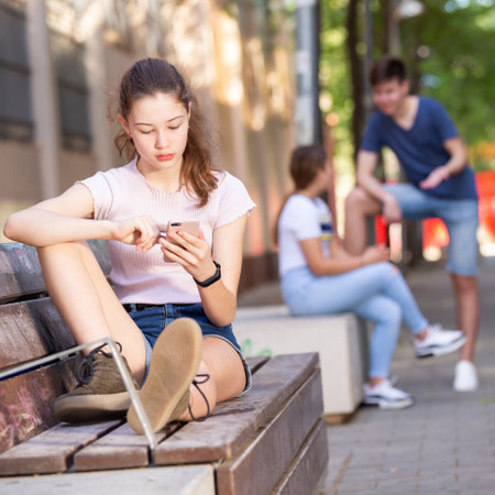 Teenage girl absorbed in social networks on phoneの写真素材