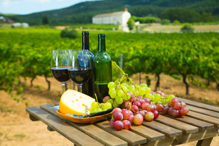 Red wine, cheese and grapes on wooden tableの写真素材