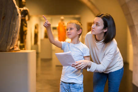 Woman and boy observing sculptures exhibitionの写真素材