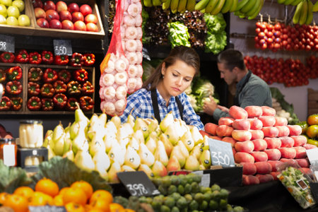 Female seller offering vegetables on marketの写真素材