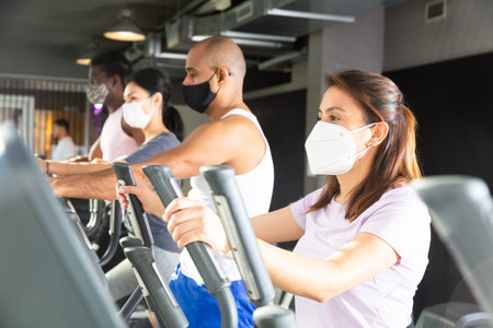 Woman training on elliptical trainer at gym