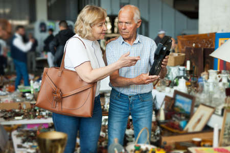Mature man and his wife are visiting market of old thingsの写真素材
