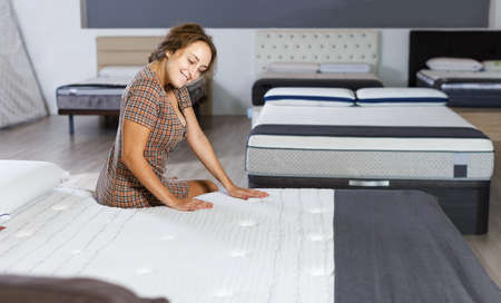 Woman choosing mattress in furnishings storeの写真素材