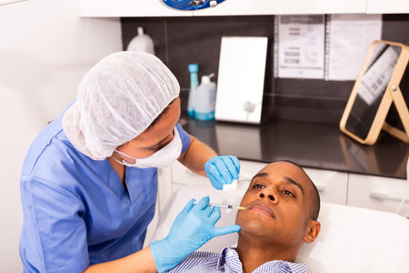Male client during face mesotherapy in cosmetology clinic