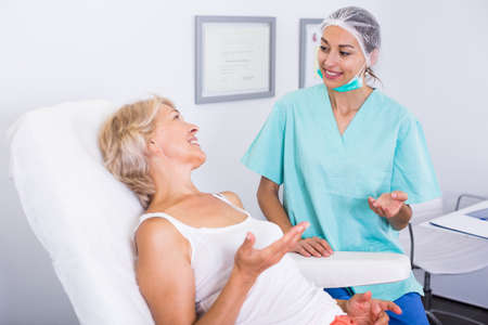 Cosmetician explaining treatment to patientの写真素材