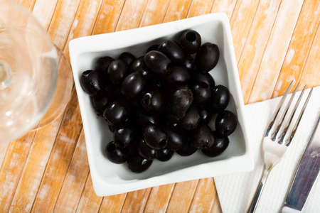 Pickled black olives in white bowlの写真素材
