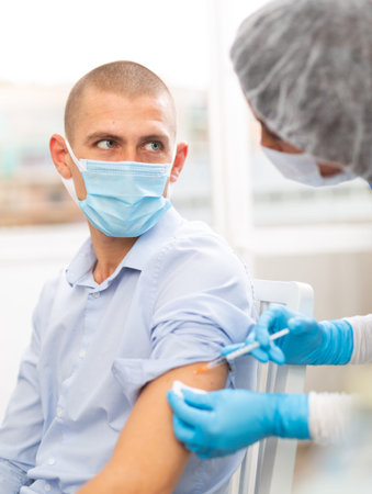 doctor in a protective face mask makes vaccinationの写真素材