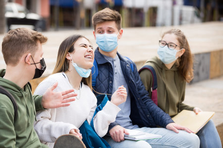 Teenage friends in face masks spending time together