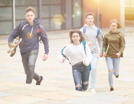 Cheerful teenagers running on city streetの写真素材