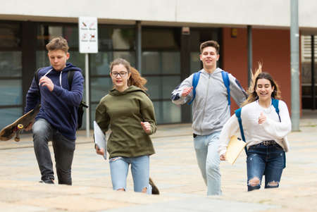 Cheerful teenagers running on city streetの写真素材