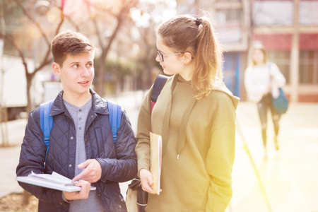 Teenage girl and boy talking outsideの写真素材