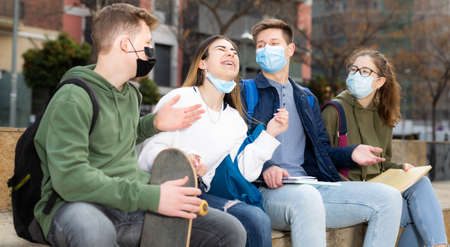 Teenagers in face masks talking outdoorsの写真素材