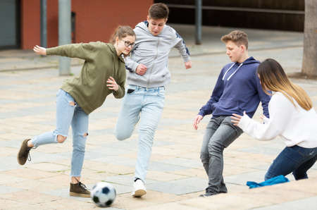 Cheerful schoolchildren are playing footballの写真素材
