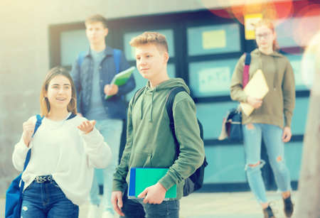 Two positive teens walk along streetの写真素材
