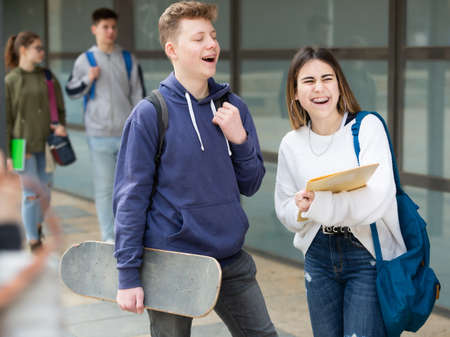 Girl and guy are discussing student issues on streetの写真素材